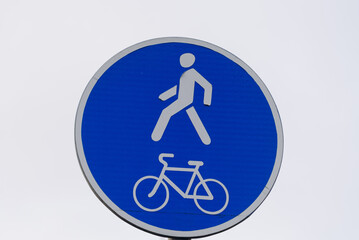 blue road sign indicating bike path and footpath
