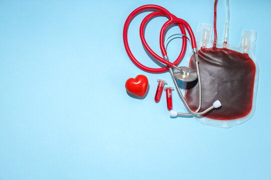 Blood bag and medical tools displayed on a blue background - Powered by Adobe