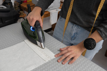 Woman sewing fabric using vintage sewing machine