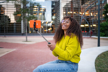 Young black woman laughing taking selfie with stick