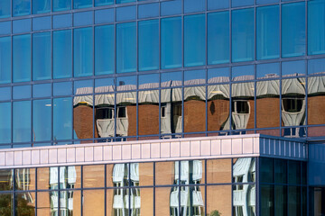 Urban architecture expressed through reflection on a glass facade where diagonal pattern, vivid color and color contrast shape each modern detail