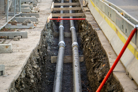 Utility Trench Excavation and Pipe Installation in City Street - Urban Infrastructure Construction Site