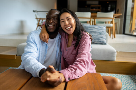 Young diverse multiethnic couple moving in new home. Couple is having fun in new house at moving day