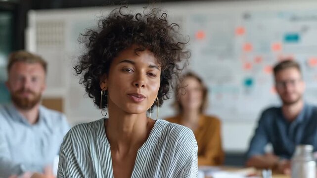 Smiling woman participating in a team meeting in a modern office setting during the afternoon