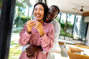 Joyful African-Asian couple embracing their diverse backgrounds, celebrating togetherness, identity