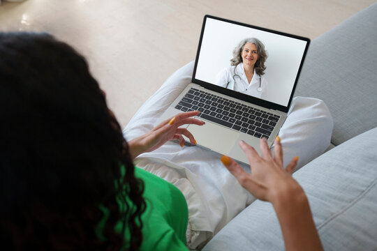 Patient on video call with doctor using laptop for telemedicine consultation