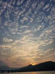 Golden Sunset Over Silhouetted Hills and Dramatic Cloudscape