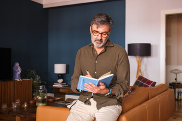 Writer making notes in a notebook at home in a relaxed atmosphere