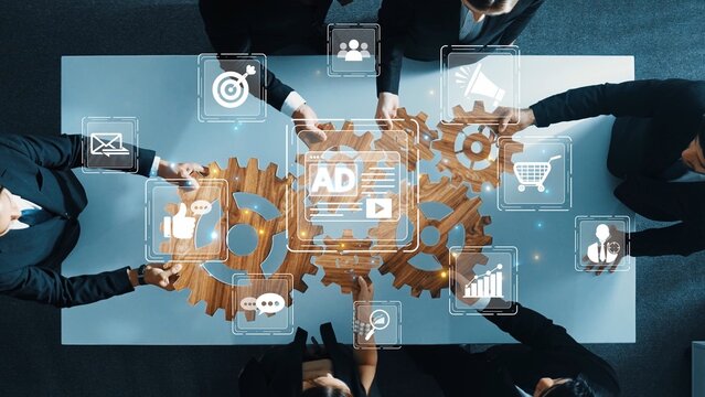 A diverse business team collaborates around a wooden table, examining strategies with digital icons representing technology, data analysis, and communication tools. Raster