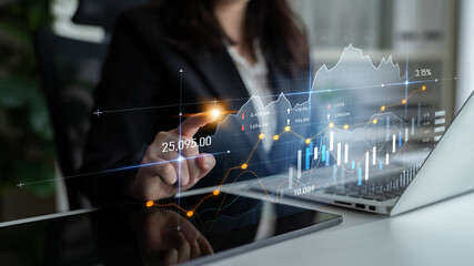 A businesswoman analyzes stock market trends using graphs and data visualization on her laptop in a modern office setting. Focus on financial metrics and technology integration. Scalp