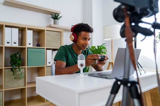 Gamer recording digital content at home with headphones and microphone