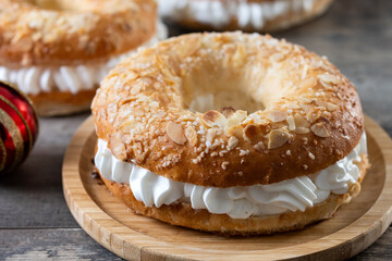 Close-up of a traditional Spanish Roscón de Reyes filled with whipped cream, decorated with sliced almonds and sugar on top