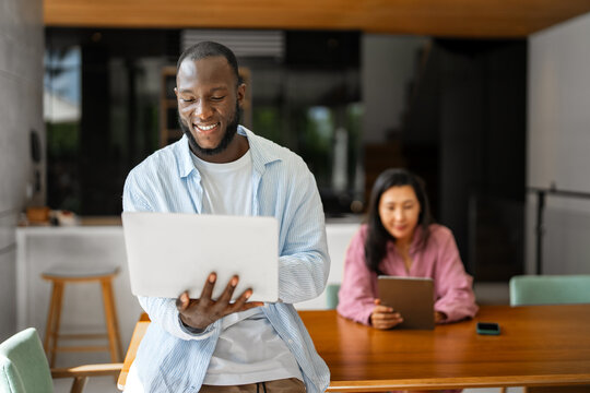 Multicultural couple working remotely, planning finances and investments online. Digital lifestyle