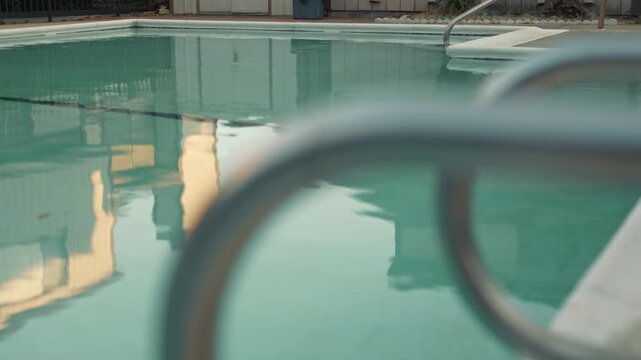 Slow movement of swimming pool water with soft reflections and blurred foreground