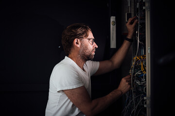 Engineer maintaining server in modern office server room