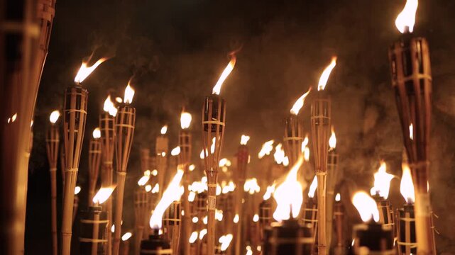 A captivating night scene of lit bamboo torches Warmflickering flames create a dramatic glow against the dark with soft bokeh lightsancient ritual cultural celebration spirit in a timeless spectacle