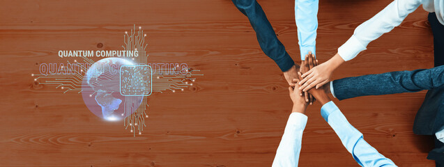 Diverse hands join in unity on a table, symbolizing teamwork in quantum computing, surrounded by futuristic technology and global connectivity concepts. Trope