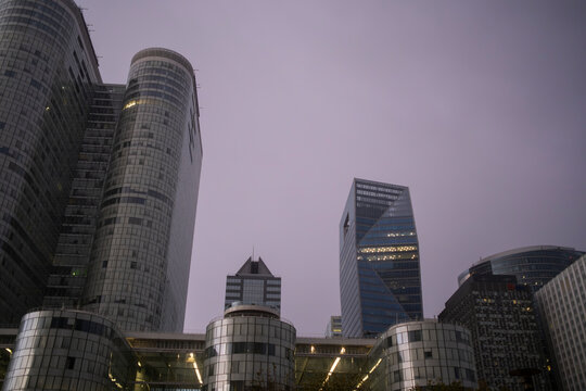 Glass and architecture shaping a compressed cityscape of finance with skyscrapers adding reflection and contrast to the urban landscape of the financial district in La Defense in Paris