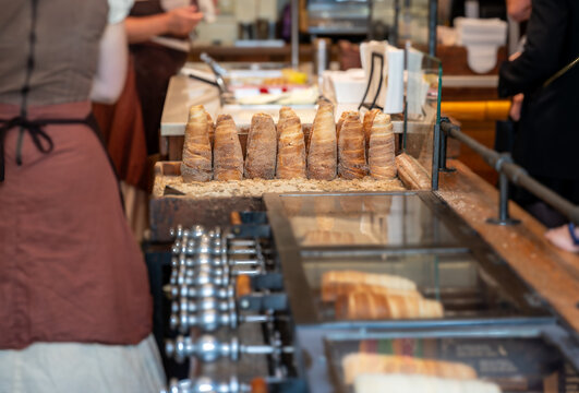 Prague,Czech Republic,August 9, 2023. A shop selling the typical local dessert, chimney cake, or tr&iacute;ldo in the local dialect. The shot shows a group ready for sale, while those baking are out of focus