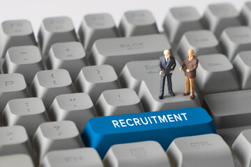 Miniature Business Figures Standing on Keyboard Button with Text Recruitment. Representing hiring processes, talent search, HR management, and employee selection.