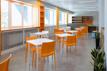 Fototapeta premium Bright and modern dining area with orange chairs in a spacious setting