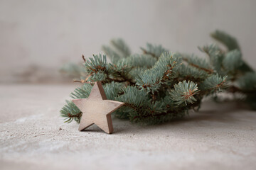 cozy arrangement of fir branches on linen accompanied by single wooden star