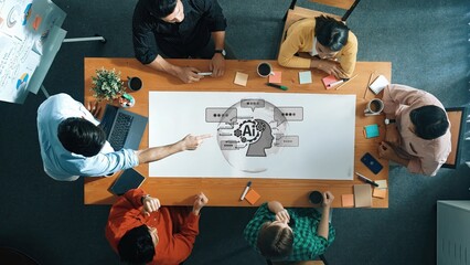 A diverse group of six individuals collaborates around a wooden table, discussing artificial intelligence topics. Laptops, sticky notes, and coffee cups enhance the creative environment. Raster