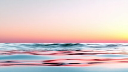A serene ocean surface with gentle waves, reflecting the soft hues of a pink and orange sunset sky.
