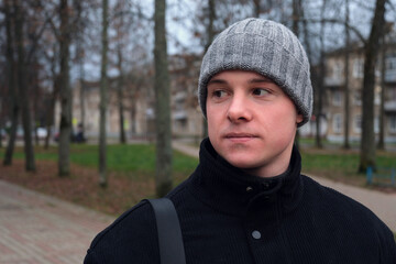 Young man on street looking away thinking