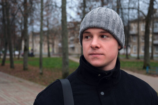 Young man on street looking away thinking