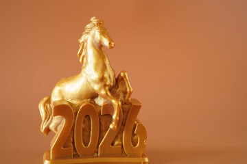 The figure of a horse and the date 2026 on a brown background. A holiday date.