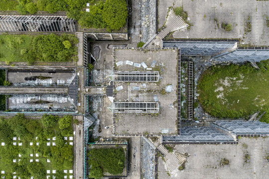 Aerial view of a concrete structure overtaken by vibrant greenery, where nature reclaims the stark architectural lines, Zagreb, Croatia.