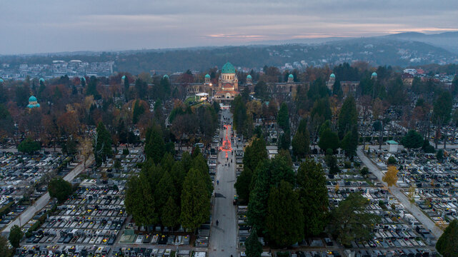 Aerial view of Mirogoj Cemetery's grand architecture under a fading sky, its domes and archways casting long shadows over the rows of graves, Zagreb, Croatia.