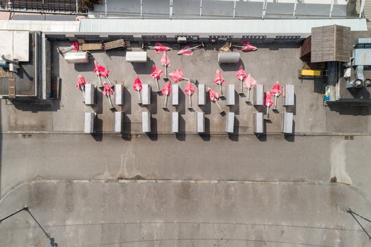 Aerial view of a flat rooftop surface with an array of gray rectangular structures topped with vibrant pink elements creating a striking contrast, Zagreb, Croatia.