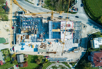 Aerial view of construction site with cranes casting long shadows over the skeletal building framework, Zagreb, Croatia.