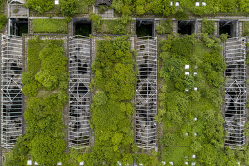 Aerial view of an abandoned structure consumed by vibrant greenery, blending nature's resilience with decaying architecture, Zagreb, Croatia.