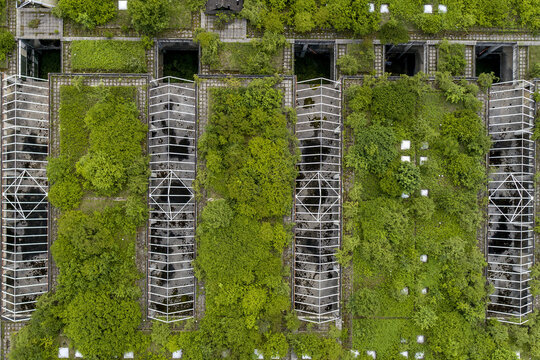 Aerial view of an abandoned structure consumed by vibrant greenery, blending nature's resilience with decaying architecture, Zagreb, Croatia.