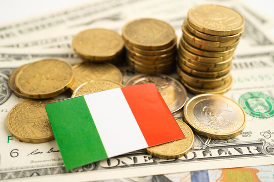 Stack of coins with Italy flag and US dollar banknotes.