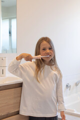 girl practicing daily dental hygiene routine, young girl engages in morning tooth cleaning activity