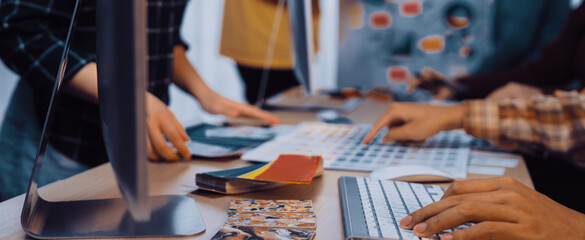 A dynamic workspace captures creative professionals collaborating on design projects, showcasing color swatches and modern technology in a vibrant atmosphere. SACTR