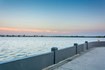 Obraz premium Serene Waterfront at Sunset: Capturing the Beauty of Nature's Transition