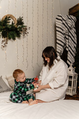 Children are eating Easter cake at the Easter table, mother is in the background