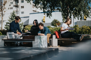 A group of young professionals collaborates outdoors on a sunny urban plaza, sharing ideas around a laptop and documents.