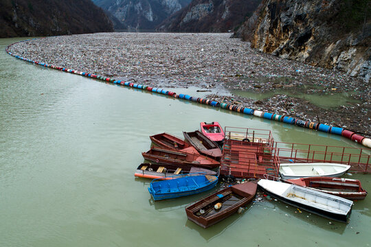Aerial view of a river choked with plastic waste, a stark contrast to the beauty of the surrounding mountains, Visegrad, Republika Srpska, Bosnia and Herzegovina.