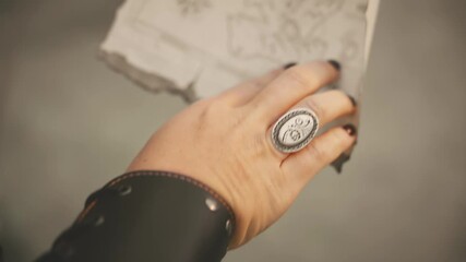 Close-up hand finger fantasy woman captain pirate holding in hands map searching for treasure. unrecognizable silhouette person looking for wealth. thief game old style. Sexy girl steampunk costume - Powered by Adobe