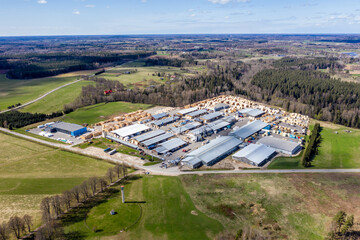 Valmiera, Latvia - May 01, 2021: Aerial view of industrial complex surrounded by lush green fields and forests in a rural landscape