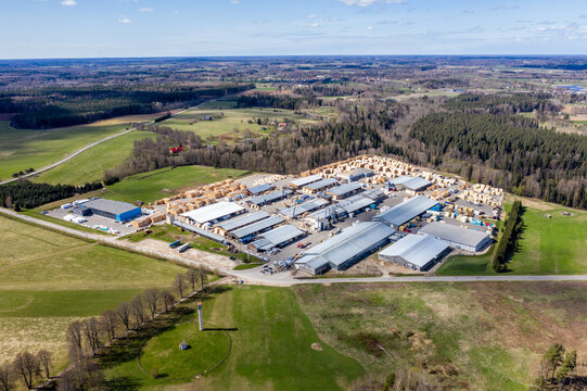 Valmiera, Latvia - May 01, 2021: Aerial view of industrial complex surrounded by lush green fields and forests in a rural landscape
