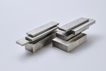 High quality close up image of stainless steel metal bars and flat sections with smooth industrial texture, suitable for construction, engineering, manufacturing, and industrial design concepts.