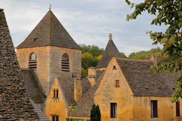 The village Saint Genies, Dordogne, France, with medieval houses (with slate roofs) and the church of Our Lady of the Assumption 