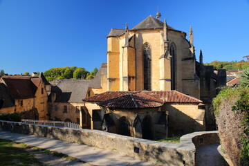 The external facade of Saint Sacerdos Cathedral, a Roman Catholic church viewed from the Eastern side in Sarlat La Caneda, Dordogne, France, and surrounded by historical medieval houses